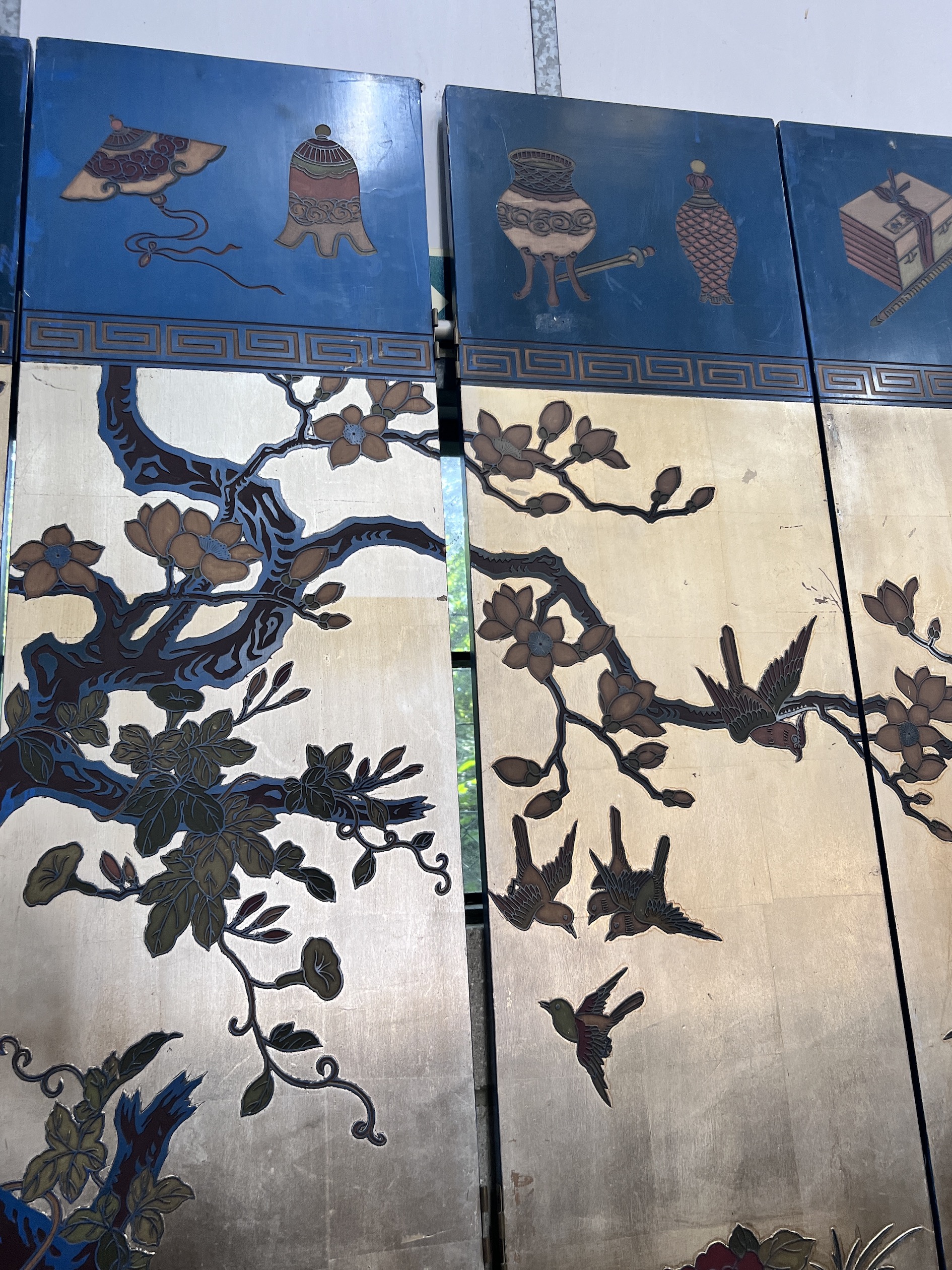 A Chinese lacquered eight fold screen decorated with exotic birds among flowering trees, each panel width 40cm, height 244cm (no fixing clips)